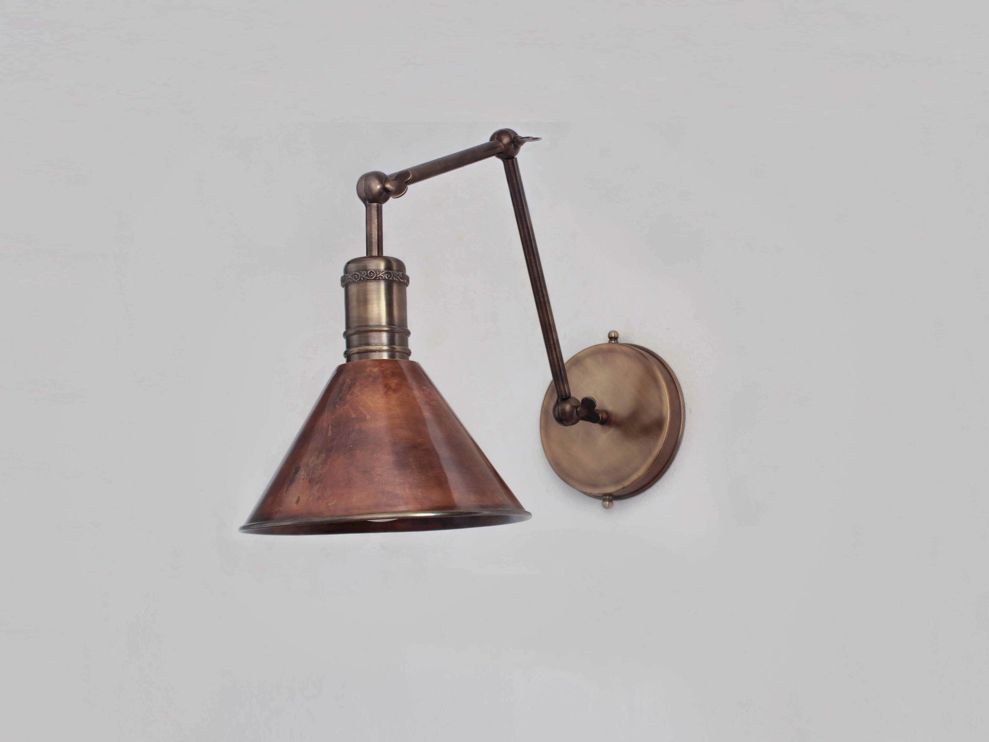 Vintage-style wall lamp with copper shade and adjustable arm on a plain background