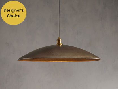 A large brass pendant light suspended from the ceiling, ideal for illuminating a kitchen island area.